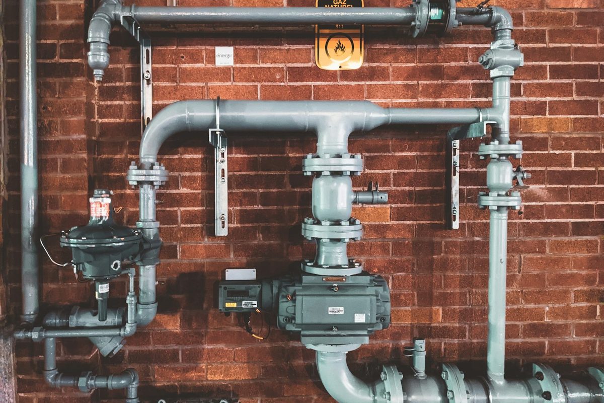 Técnico localizando vazamento oculto na parede do banheiro com aparelho eletrônico